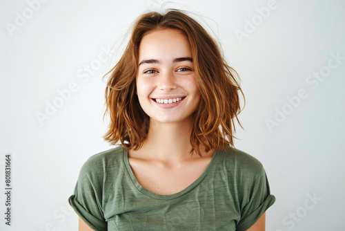 portrait of smiling woman with brown hair, wearing a green tshirt on a white background, looking at the camera in a half body shot