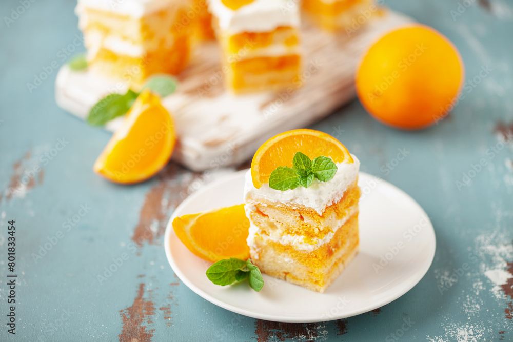 Slices of creamsicle cake on wooden cutting board. Orange fruit cake. Slices of creamsicle cake on wooden cutting board. Orange fruit cake.