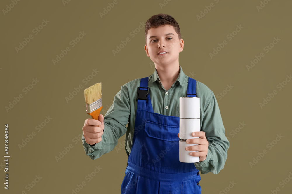 Teenage decorator with brush and paint cans on green background Teenage decorator with brush and paint cans on green background