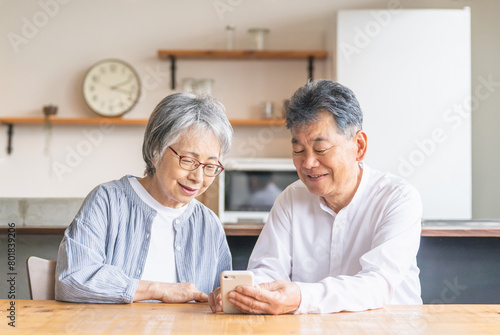 スマホ・スマートフォンのアプリを使うアジア人高齢者夫婦（笑顔・楽しい）
 photo