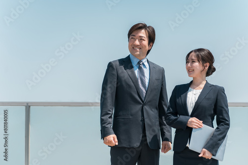 青空を見上げるスーツ姿のビジネスマン男女（希望・就職・転職・就職活動・リクルート） 