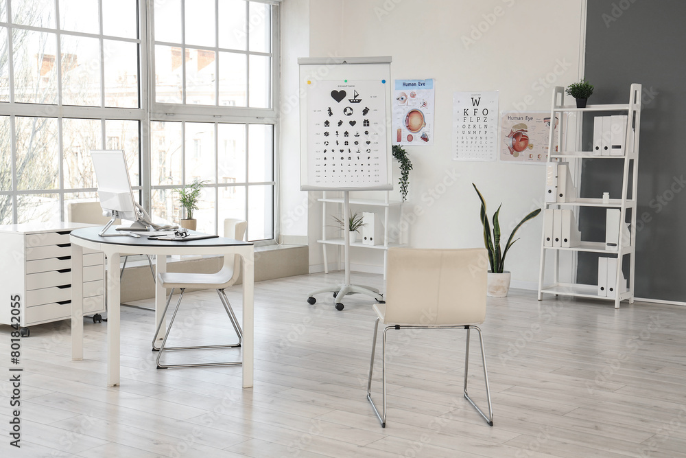 Interior of oculist's office with workplace and eye test charts Interior of oculist's office with workplace and eye test charts