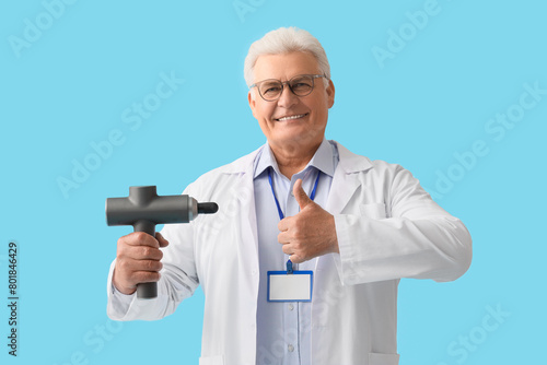 Smiling senior doctor holdi...