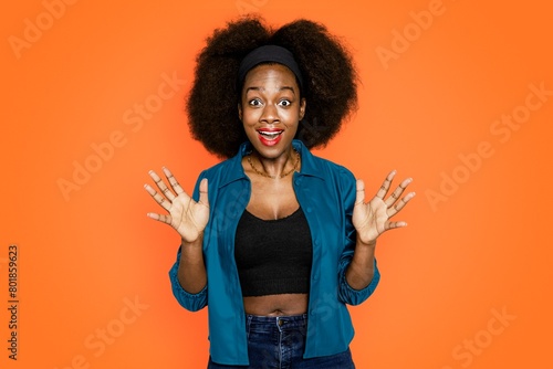 Surprised African American woman on orange background