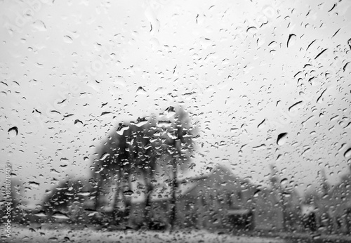 View on winter town through wet windshield with rain drops. Black and white