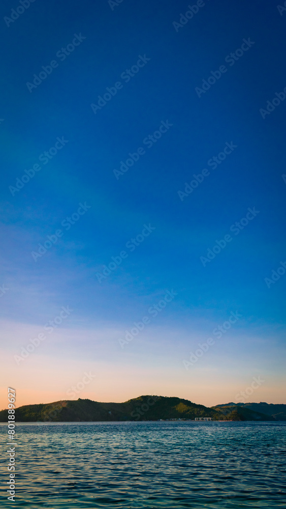 Golden sunset at sea. Portrait. Bonbon Beach, Romblon Island, Philippines