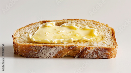 slice of freshly baked sourdough bread, adorned with a generous spread of creamy butter, exuding warmth and comfort with its golden crust and soft interior.