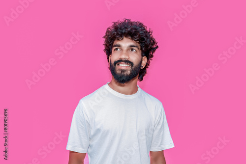 Handsome joyful smiling young indian man looking aside up and straight thinking of new good opportunities, dreaming, feeling inspired and proud standing isolated on pink background. Portrait