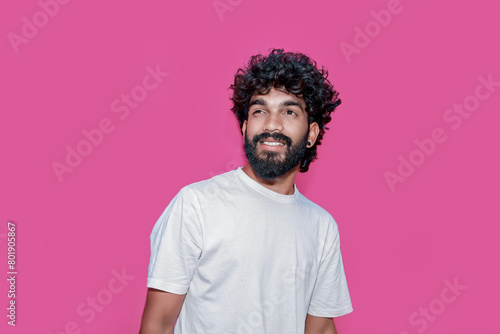 Handsome joyful smiling young indian man looking aside up and straight thinking of new good opportunities, dreaming, feeling inspired and proud standing isolated on pink background. Portrait