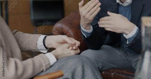 Close-up of hands female therapist and male patient gesturing and talking during consultation in office. Psychological aid and therapy concept.