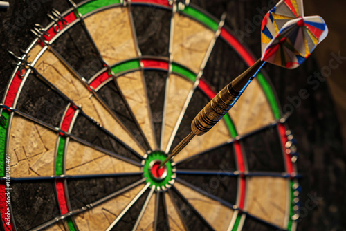 A dart lands perfectly centered in the bullseye