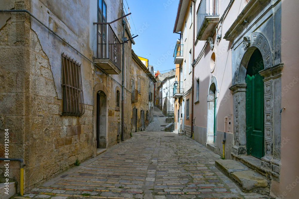 Fototapeta premium A street among the old houses of Macchia Valfortore, a medieval village in Molise, Italy.