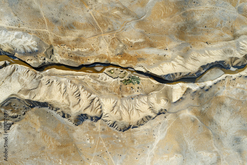 An aerial view of a dried-up riverbed after being washed away by the river, with a vast expanse of land.