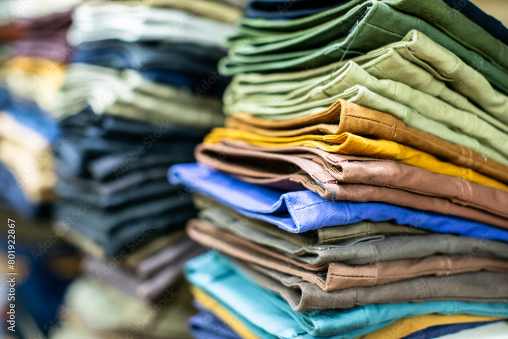 Lots of clothes folded and stacked on shelves in a clothing store. Lots of clothes folded and stacked on shelves in a clothing store.