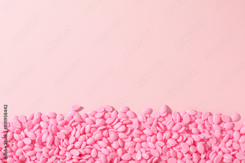 Obraz premium Wax granules for depilation on a pink background
