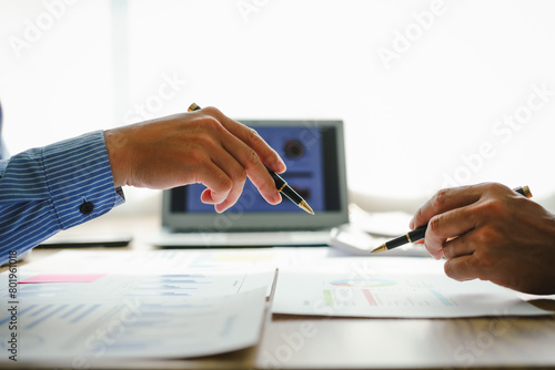 Desk-bound businessman calculates figures, verified accounts, and collaborates in discussions. Proficient in using calculators, aiding each other, and managing annual tax accounts in the audit office photo