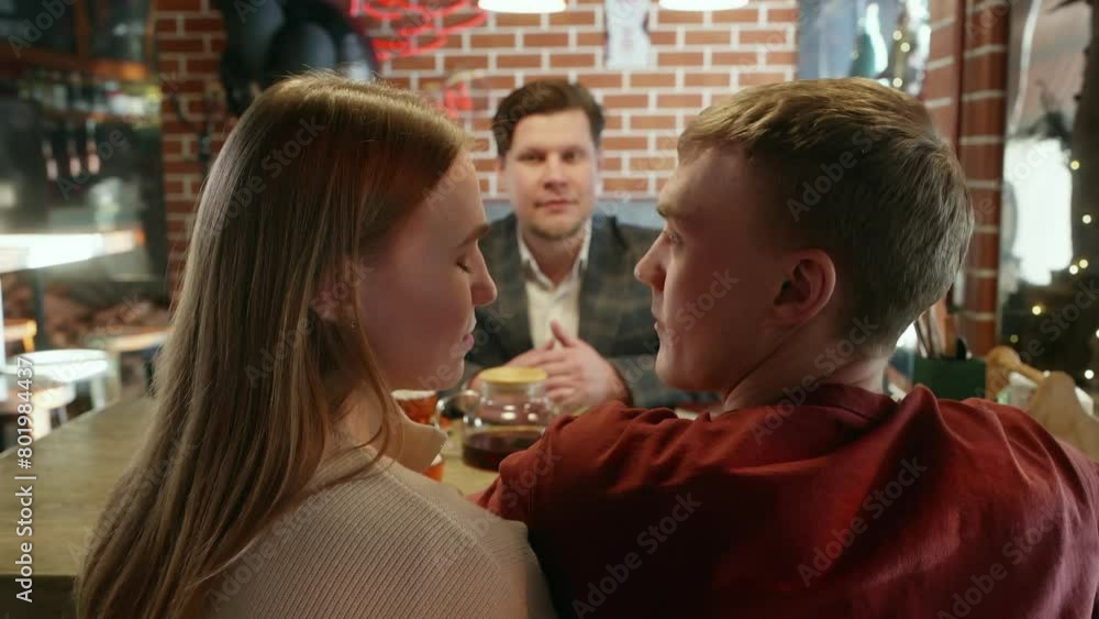 Young couple talking with event planner. Woman convincing partner during discussion in informal meeting. They are sitting at table in restaurant persuades, asks, begs, convinces Young couple talking with event planner. Woman convincing partner during discussion in informal meeting. They are sitting at table in restaurant persuades, asks, begs, convinces