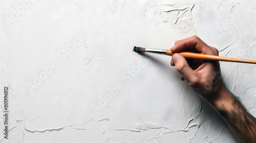 artist's hand initiating a creative journey on textured white canvas