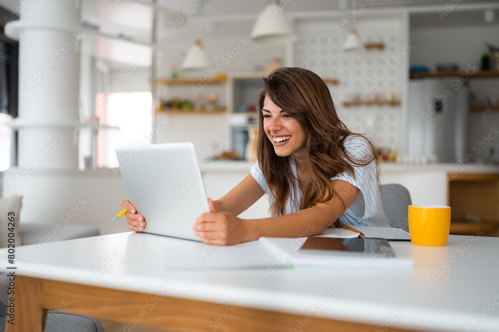 Smiling female business person talking by conference online virtual chat using laptop computer at home office sitting at desk. Smiling female business person talking by conference online virtual chat using laptop computer at home office sitting at desk.