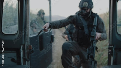 Special forces getting into a moving vehicle near fields outdoors