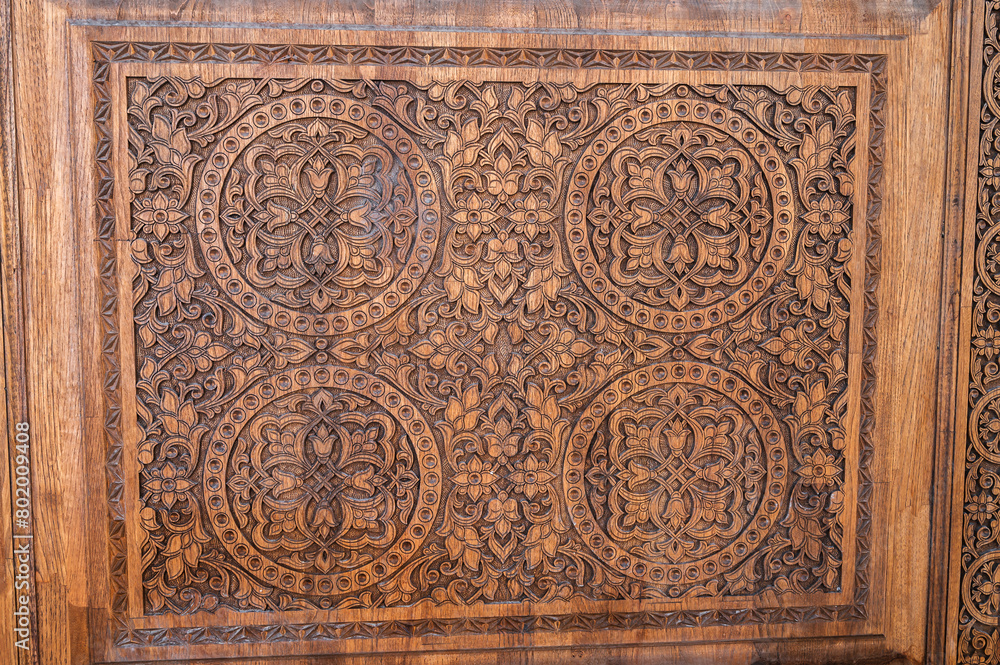 traditional oriental Tajik patterns arabesque ornament in kandakori bagdadi style on an ancient wooden carved door in Tadjikistan