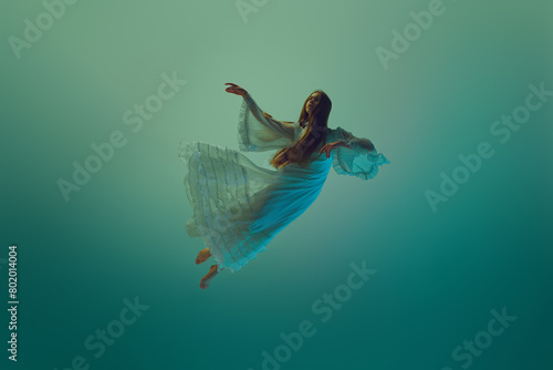 Wallpaper Mural Woman in stunning dress, gracefully suspend in mid-air, conveys sense of fluidity and grace against serene aqua background. Concept of underwater fantasy, freedom and weightlessness, mystery and depth Torontodigital.ca
