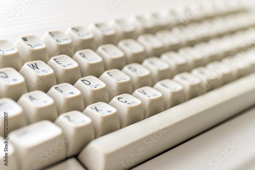 Close-up of vintage Commodore 64 keyboard with cream-colored keys and letters. Daylight illuminating the retro computer. photo