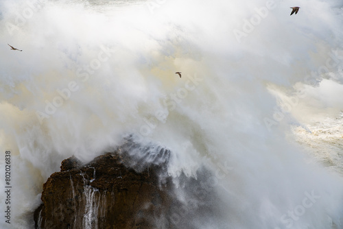 Big wave exploding on cliff in Nazaré, Portugal