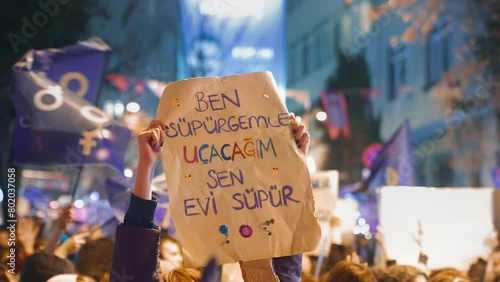 Translation: I will fly my broomstick you can vacuum the house. Feminist walk. 8 march feminism protest. Demonstration banner. Woman riot. Female rights picket. Girl power. People hold strike placards photo