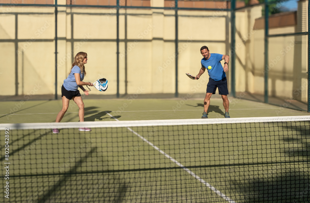 Energetic Padel Match Between Middle-Aged Couple