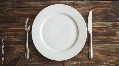 Empty white plate on table with fork and knife