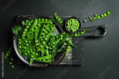 Green young peas on a dark stone background. Healthy food. Top view. © Yaruniv-Studio