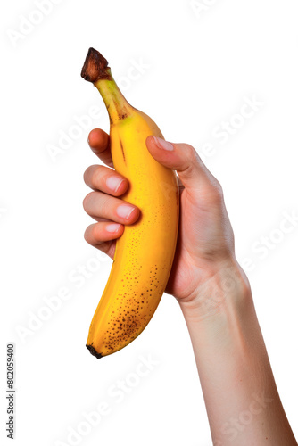 A person is holding a banana in their hand isolated on a cutout PNG transparent background. The banana is yellow and has a few brown spots