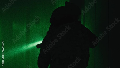 Two soldiers with guns walking down a corridor night-vision