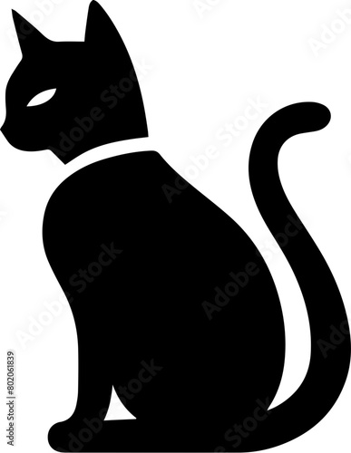 A black cat is sitting with its tail curled around its paws. It is wearing a collar with a tag on it. The cat is looking off to the side.