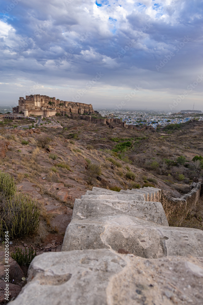 ancient historical fort with colored city houses and dramatic cloudy sky at evening