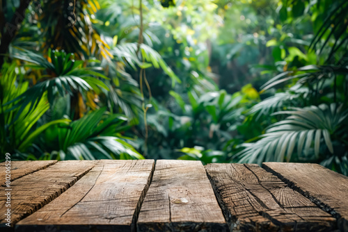A wooden table with a view of a lush green jungle. The table is empty and the jungle is full of trees and plants
