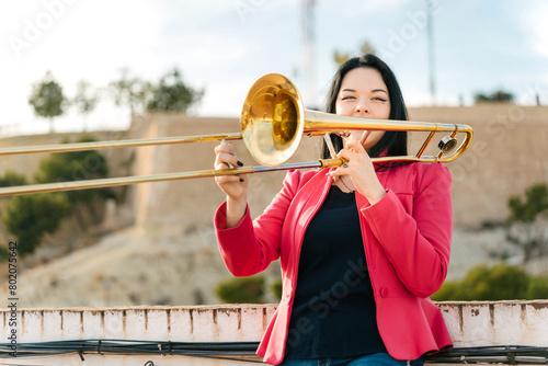 Young girl trombonist playing cheerful photo