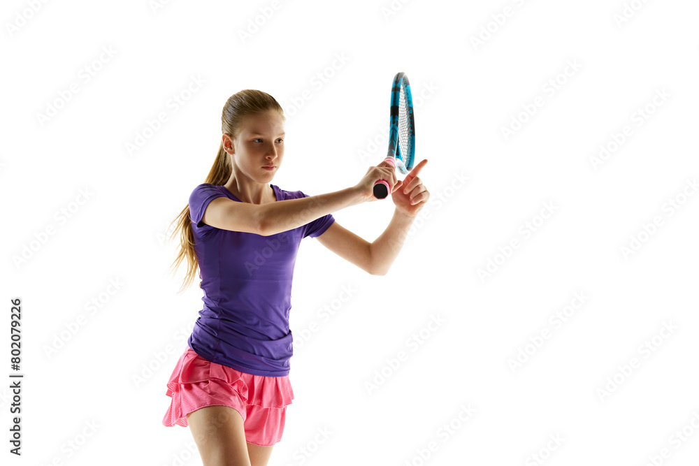 Portrait of focused young girl, tennis player ready to hit ball in motion against white studio background. Model in vibrant uniform. Concept of professional sport, movement, tournament, action. Ad Portrait of focused young girl, tennis player ready to hit ball in motion against white studio background. Model in vibrant uniform. Concept of professional sport, movement, tournament, action. Ad