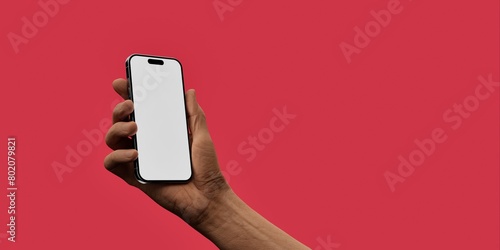Male hand holding a smartphone with a blank screen against red background