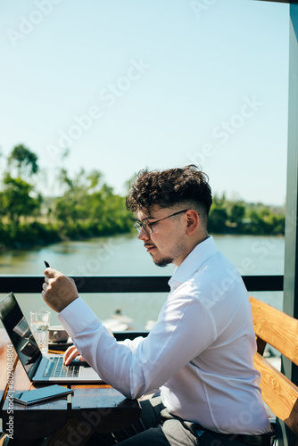 Young man pays online with a credit card. 
Young man shopping online with a credit card and a laptop outdoors
