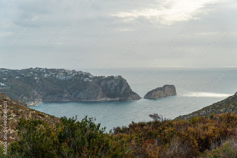 Panoramic view, cliffs and Mediterranean sea on a cloudy morning day, in Jávea, Alicante (Spain).