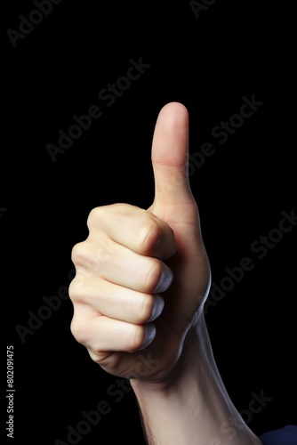 A hand is raised with a thumb up, giving a thumbs up sign