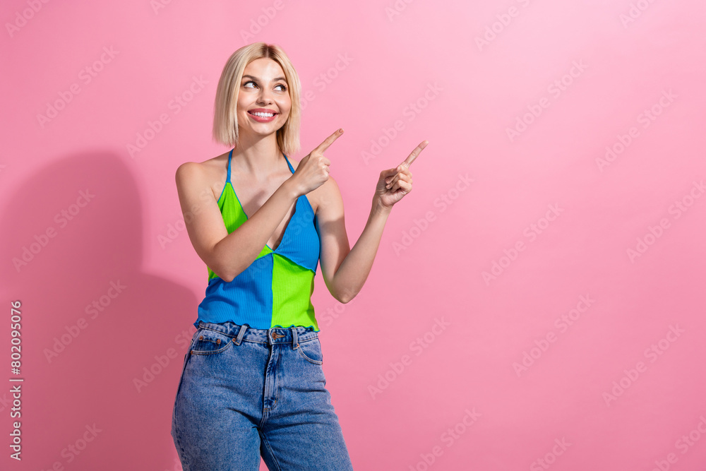 Photo of cheerful girl with bob hairdo dressed colorful tank look directing at promo empty space isolated on pink color background Photo of cheerful girl with bob hairdo dressed colorful tank look directing at promo empty space isolated on pink color background