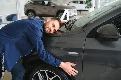 Young man is choosing a new vehicle in car dealership