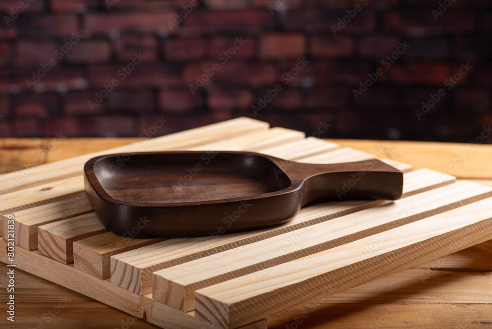 Wooden tray, details of an empty wooden tray on rustic wooden surface, selective focus.