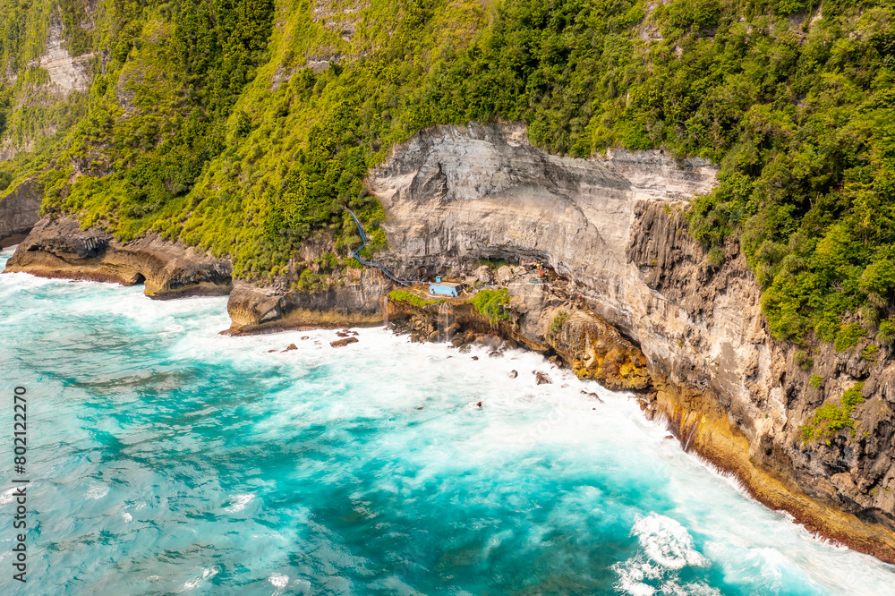 Clean calm blue sea with white foam near shore. Drone view high cliff. Bali, Klungkung, Indonesia Clean calm blue sea with white foam near shore. Drone view high cliff. Bali, Klungkung, Indonesia