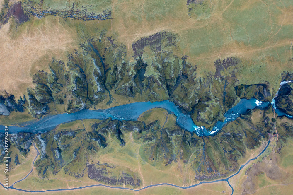 Winding blue riverbed flowing between rocks in Iceland, natural amazing landscape. Drone shot. Winding blue riverbed flowing between rocks in Iceland, natural amazing landscape. Drone shot.