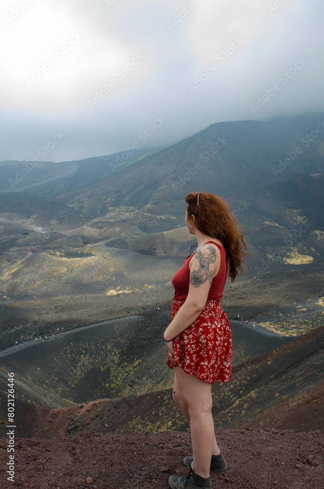 Naklejka premium Femme de dos regardant un cratère de volcan