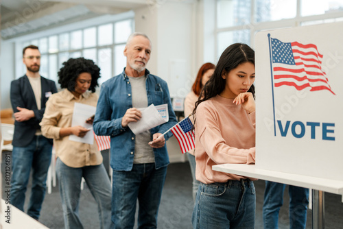 Vászonkép Asian woman standing in voting booth, voting, group of multinational US citizens